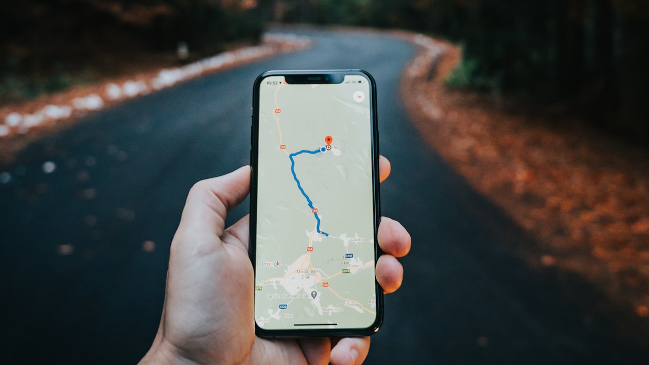 A hand holding a smartphone showing a navigation map