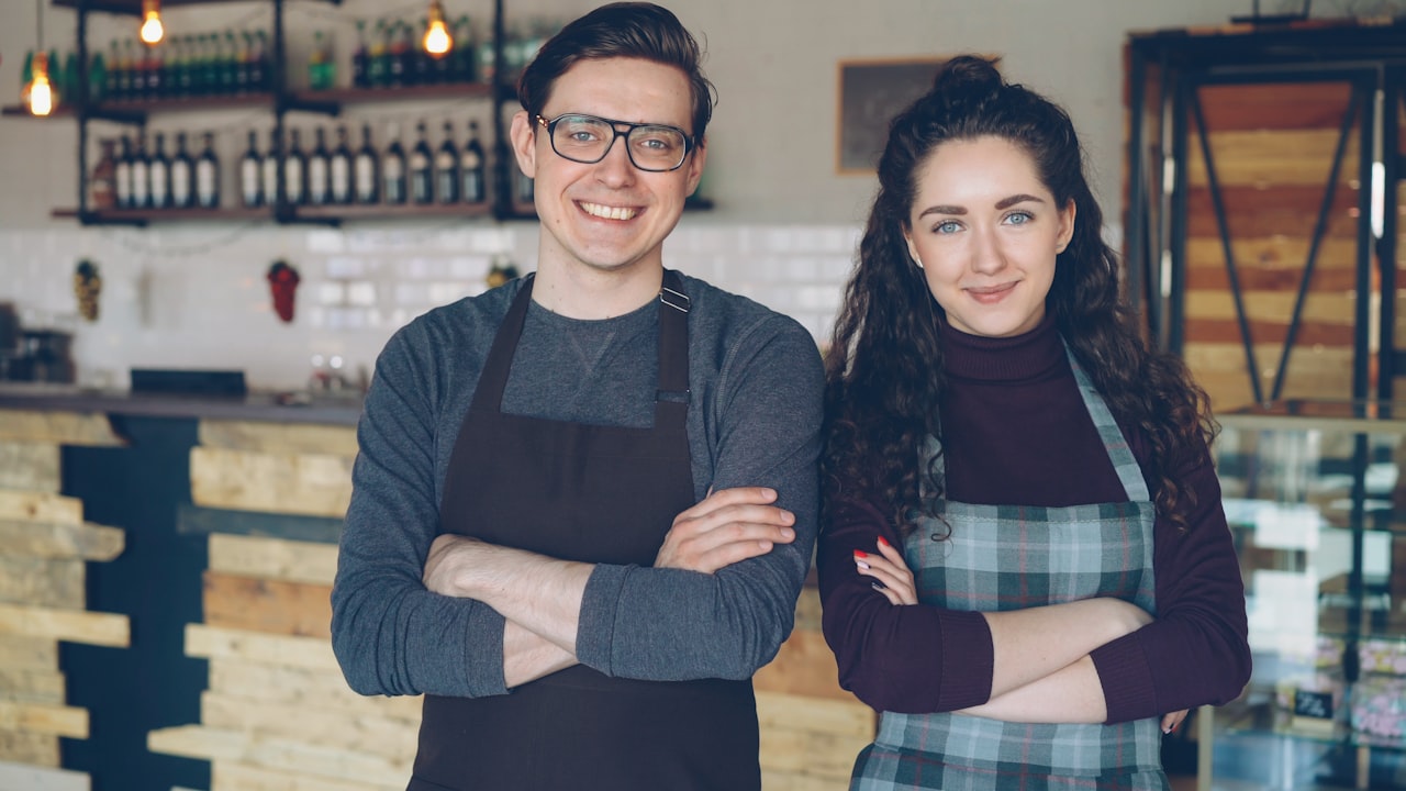 Two proud local café owners standing together in their shop