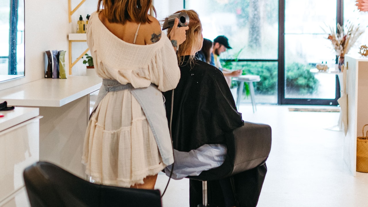 A client having her hair styled in a salon chair