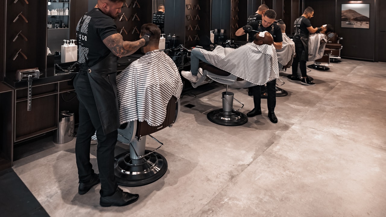 A barber cutting a client's hair in a modern barbershop