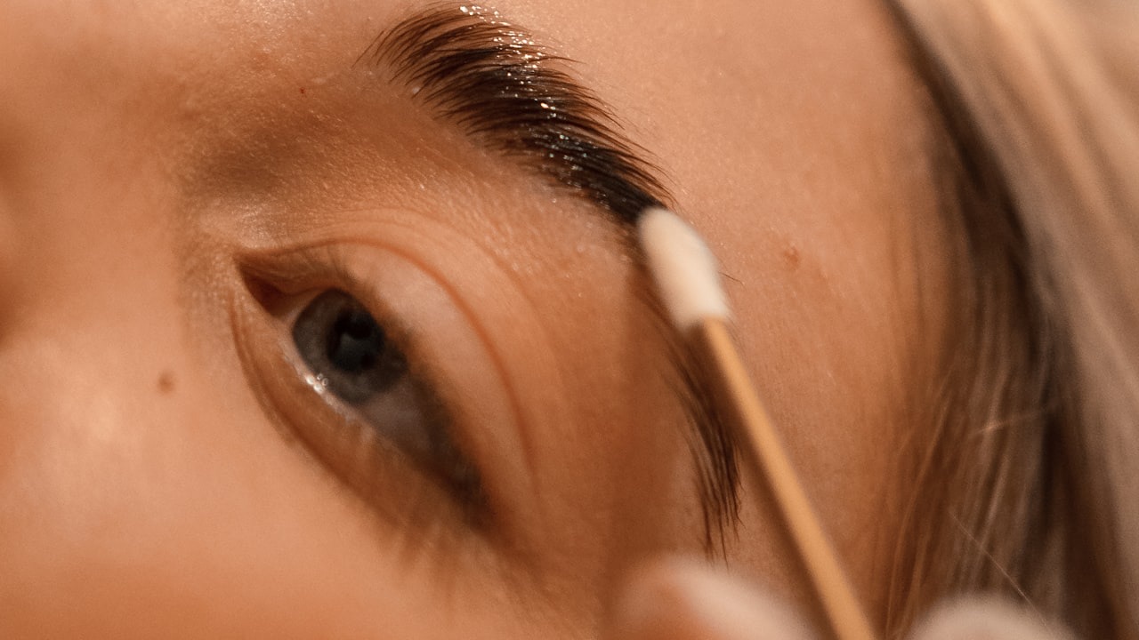 A brow artist grooming a client's eyebrow